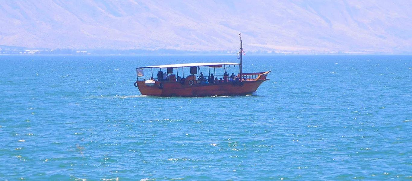 Passeio de barco pelo Mar da Galileia, como nos tempos de Jesus Turistas em passeio de barco pelas águas do Mar da Galileia, revivendo experiências dos tempos de Jesus e seus discípulos
