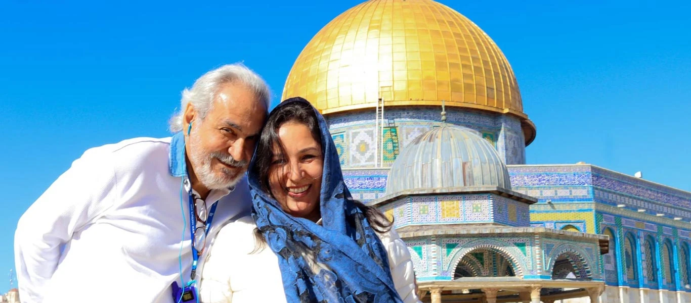 Casal de turistas sorrindo em frente ao Domo da Rocha em Jerusalém Casal feliz posando para uma linda foto com o Domo da Rocha ao fundo, um dos marcos mais icônicos de Jerusalém